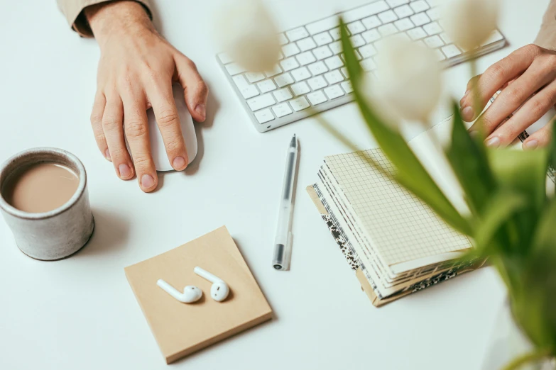 a person typing on a keyboard next to a cup of coffee, trending on pexels, arbeitsrat für kunst, earbuds jewelry, 9 9 designs, no - text no - logo, white mouse technomage