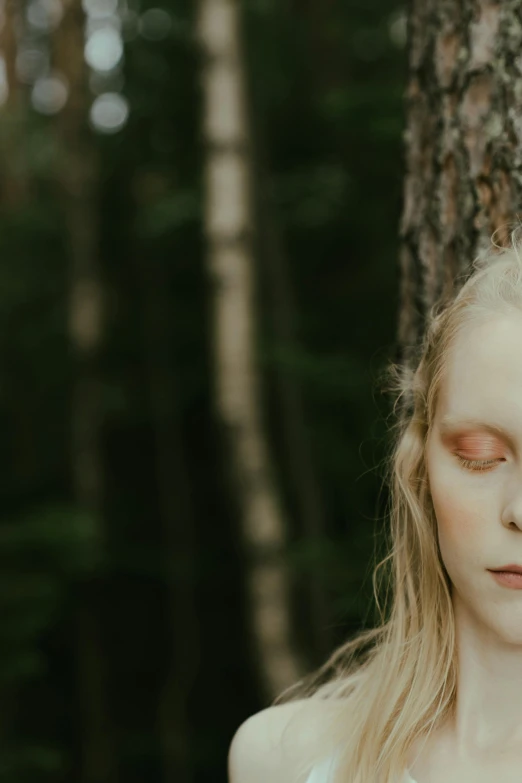 a woman standing next to a tree with her eyes closed, unsplash, magical realism, beautiful pale makeup, kalevala, still from a movie, ((forest))