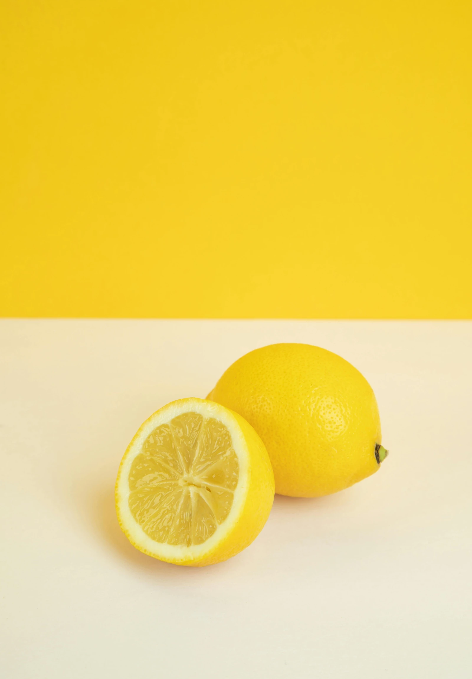 two lemons sitting next to each other on a table, by Carey Morris, trending on unsplash, postminimalism, yellow background beam, 15081959 21121991 01012000 4k, plain background, focus on full - body