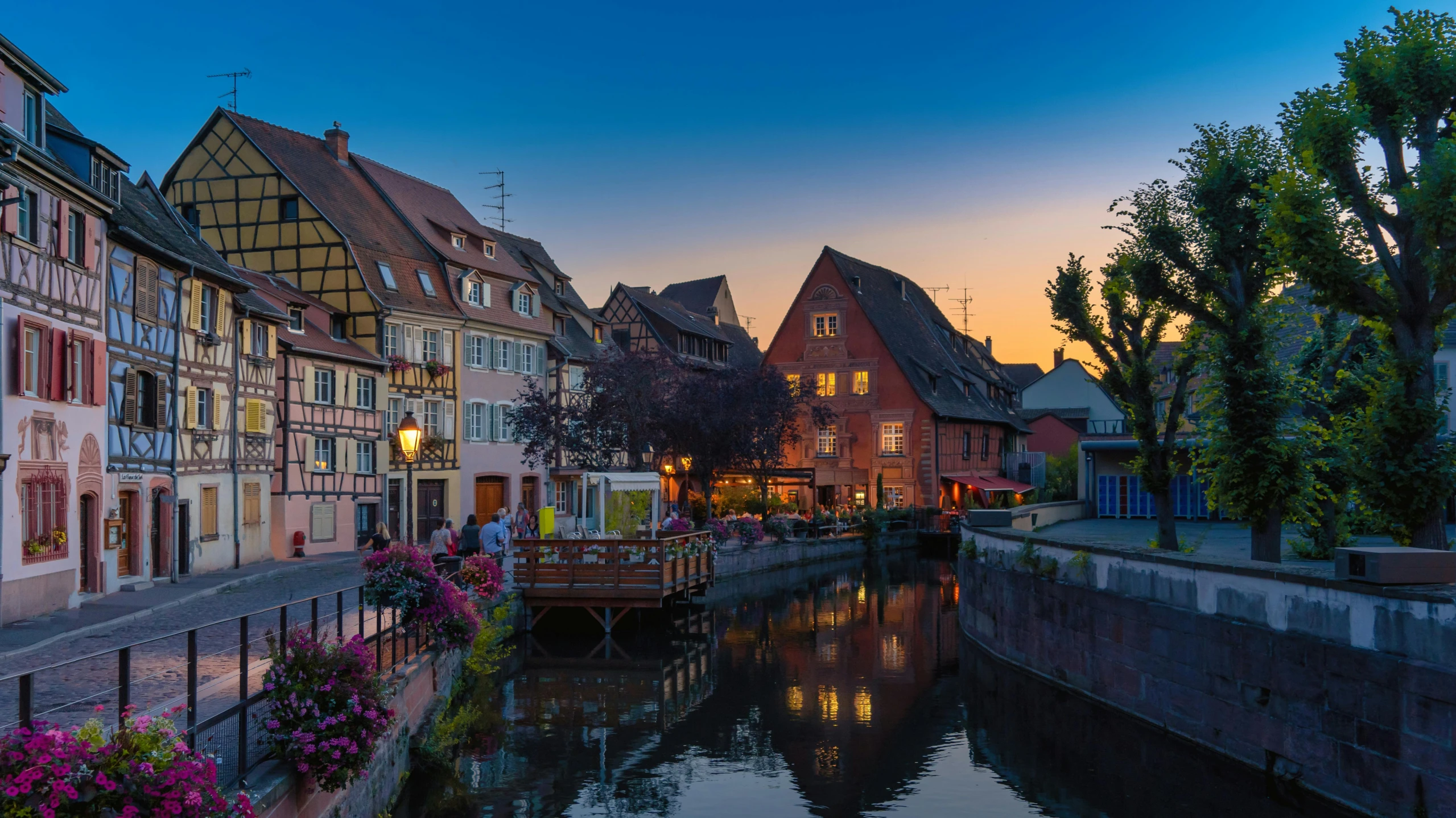 a river running through a small town next to tall buildings, pexels contest winner, renaissance, beautiful dusk, french village exterior, 3 - piece, pink