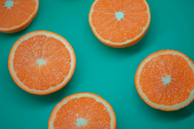 a group of oranges sitting on top of a green surface