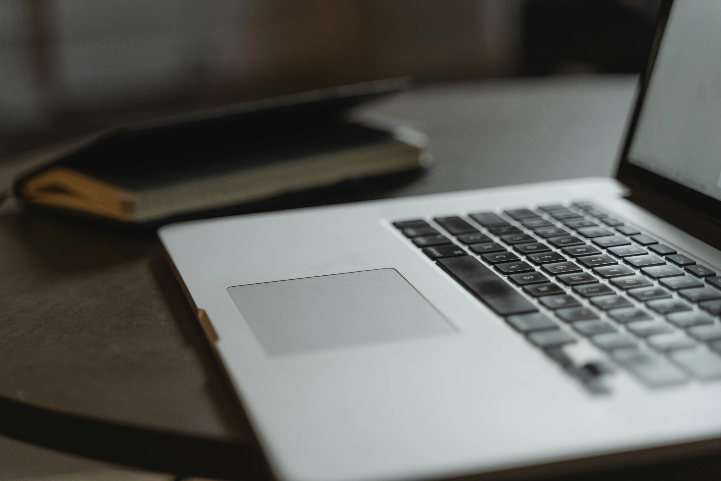 a laptop computer sitting on top of a wooden table, pexels, close - up photo, background image, close up photograph, alessio albi