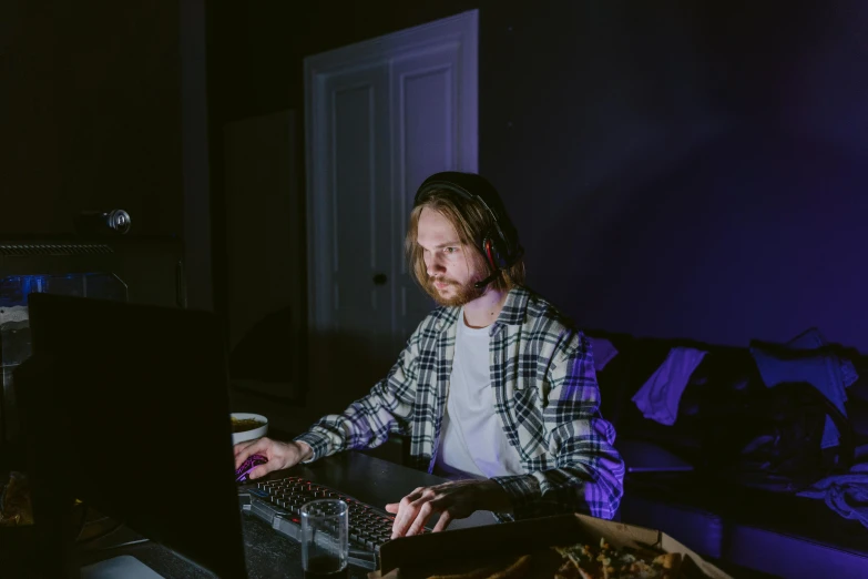 a man sitting in front of a laptop computer, inspired by Elsa Bleda, pexels contest winner, violet lighting, asmongold, low iso, indie game
