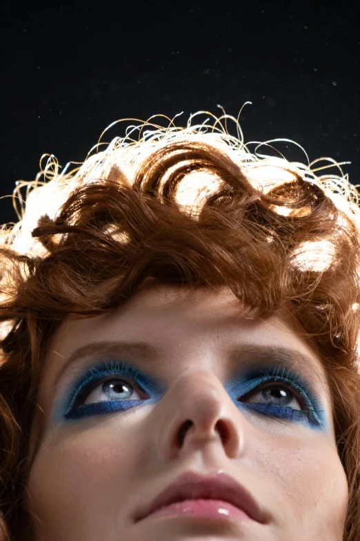 a close up of a woman with red hair, an album cover, inspired by Cindy Sherman, trending on pexels, sparkling blue eyes, looking upwards, curls on top of his head, azure. detailed hair