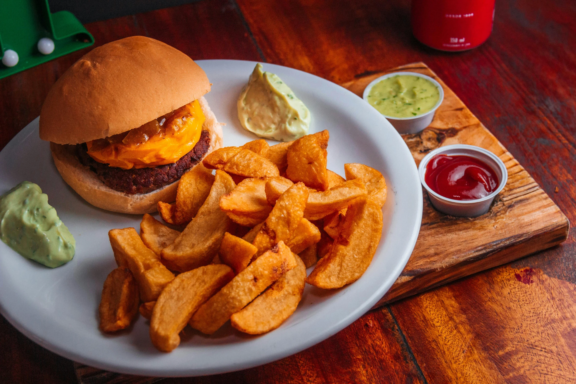 a white plate topped with a burger and french fries, by Joe Bowler, pexels contest winner, chips, peruvian looking, a wooden, background image