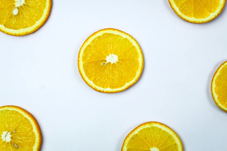 a group of orange slices sitting on top of a white surface, by Carey Morris, trending on pexels, minimalism, 🦩🪐🐞👩🏻🦳, yellow aureole, background image, ultrawide image