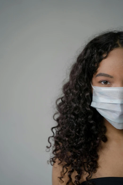 a woman with curly hair wearing a face mask, by Adam Marczyński, medical image, black teenage girl, gauze, asian human