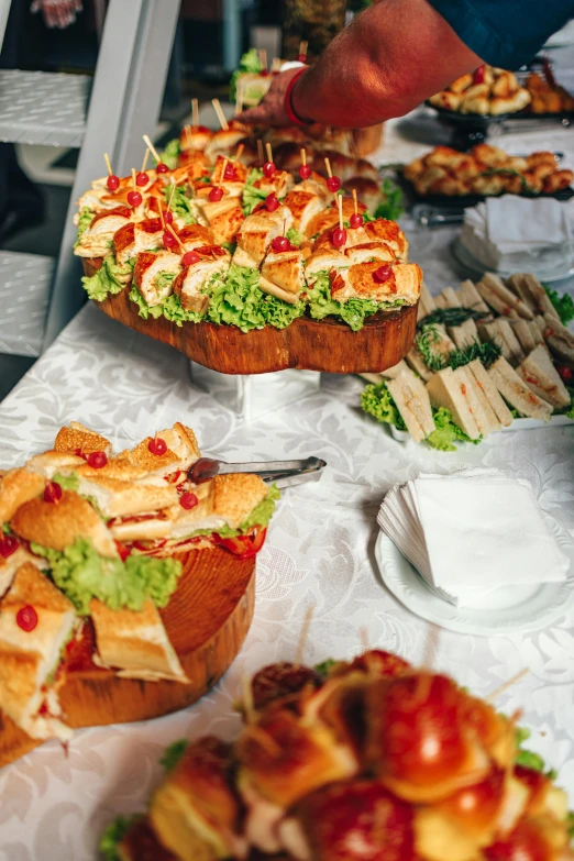 a table topped with lots of different types of food, sandwich, a high angle shot, on a table, event