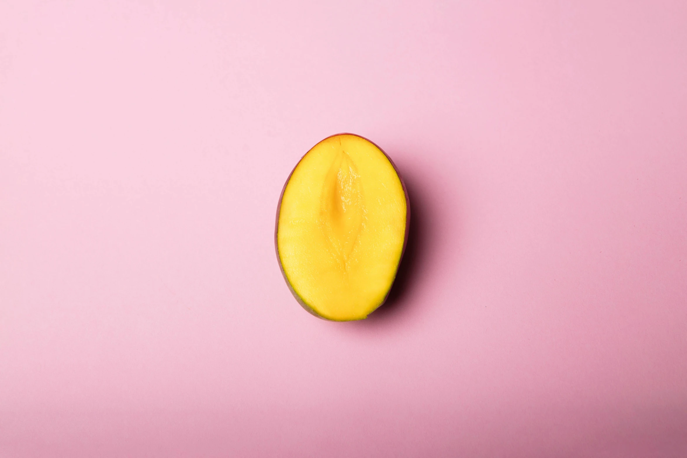 a sliced mango on a pink background, trending on pexels, olive skin, yellow aura, olive, single light