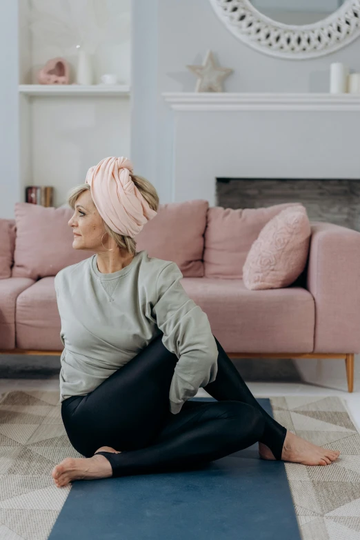 a woman sitting on a yoga mat in a living room, by Elsie Henderson, pexels contest winner, arabesque, pink headband, panoramic shot, profile image, at the sitting couch