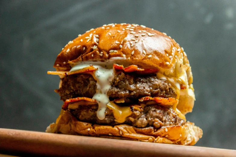 a cheeseburger sitting on top of a wooden cutting board, a portrait, by Joe Bowler, unsplash, crispy buns, stacked, 🦩🪐🐞👩🏻🦳, malaysian