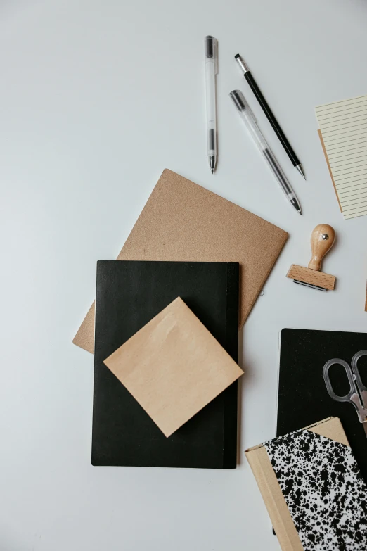 a variety of office supplies laid out on a table, trending on unsplash, visual art, black and brown, square shapes, thumbnail, cardstock