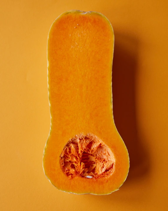 a butternut cut in half on a yellow surface, inspired by Michelangelo, trending on unsplash, gradient orange, lgbtq, translucent body, asian male