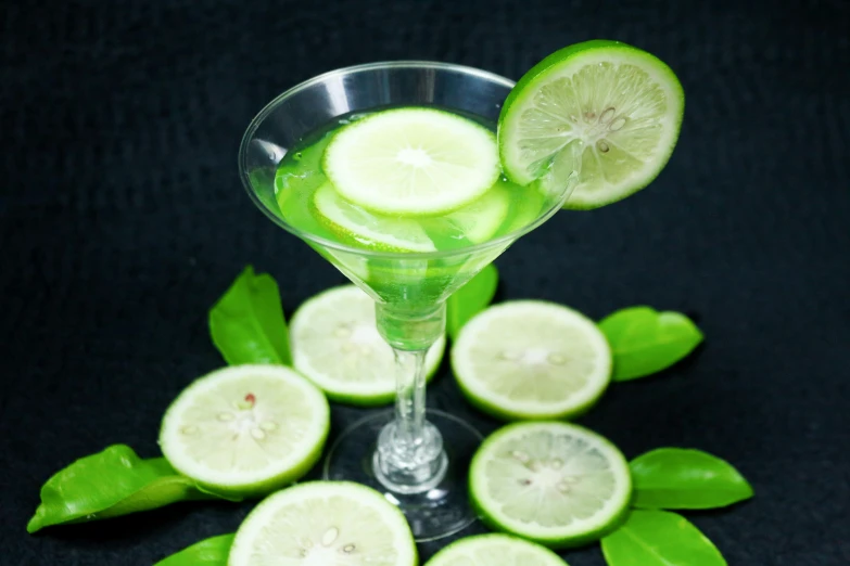 a martini glass filled with green liquid and sliced limes, in style of lam manh, thumbnail, sasai ukon masanao, greens)