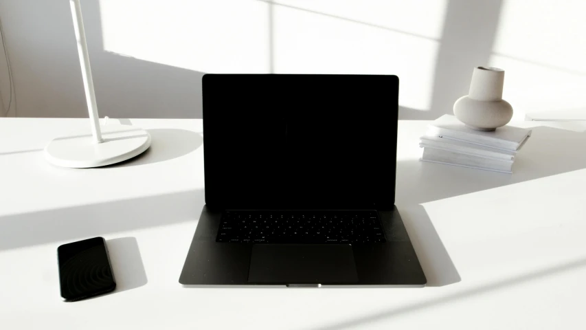 a laptop computer sitting on top of a white desk, unsplash, vantablack, background image, no text, computers