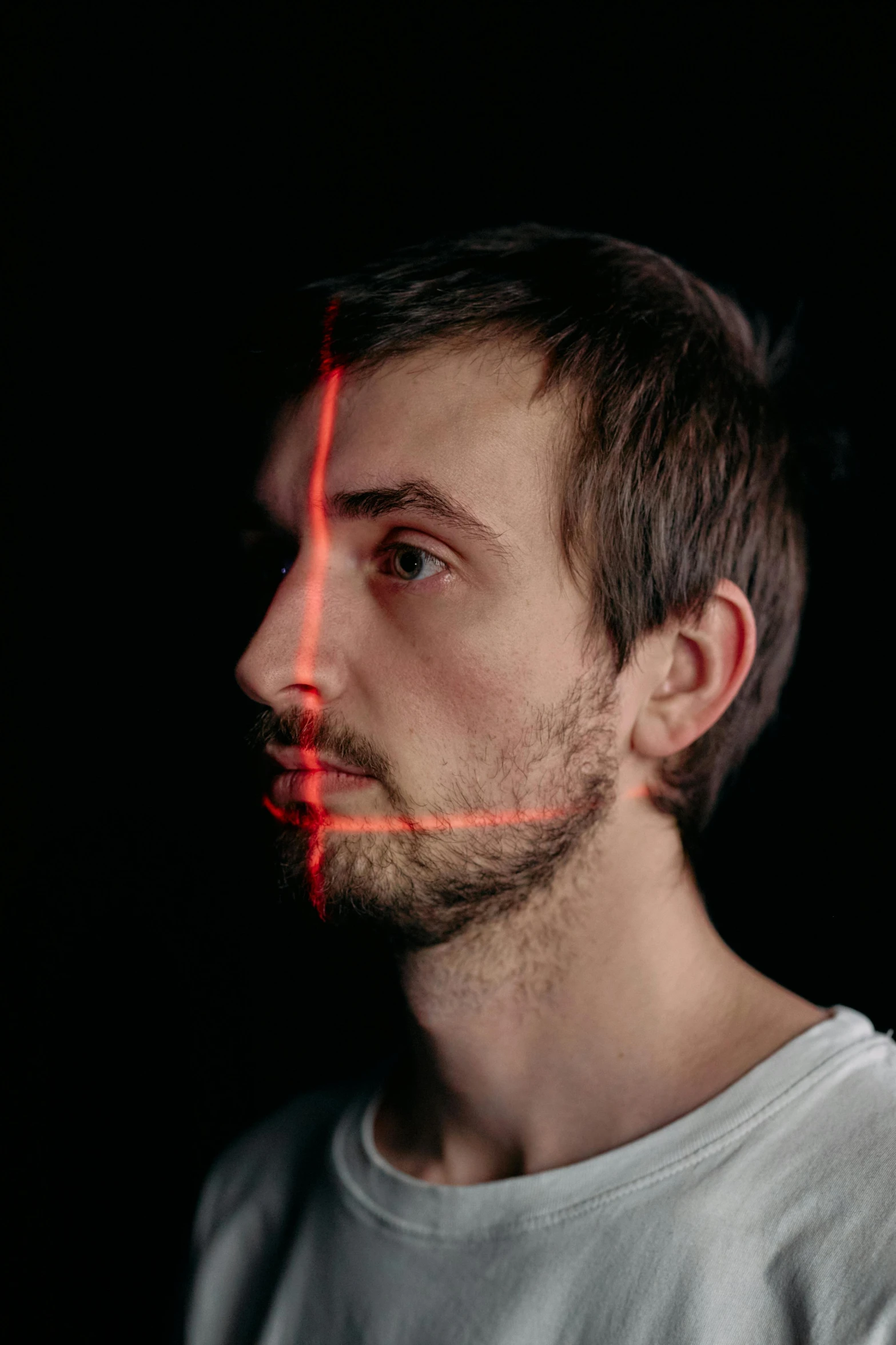 a man with a red light on his face, by Adam Marczyński, trending on pexels, holography, square jaw-line, half - length head portrait, slender nose, thin young male