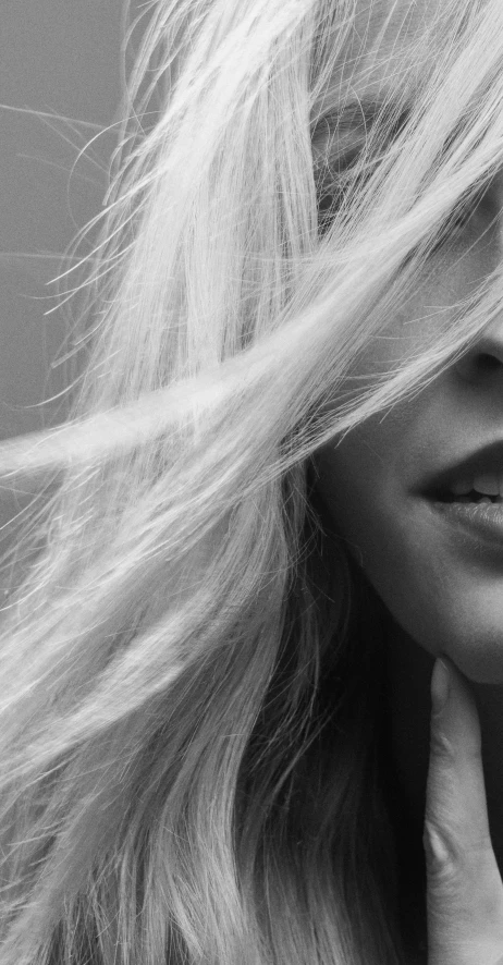 a black and white photo of a woman with long hair, inspired by Károly Lotz, unsplash, photorealism, close up of a blonde woman, tongue out, banner, low quality photo