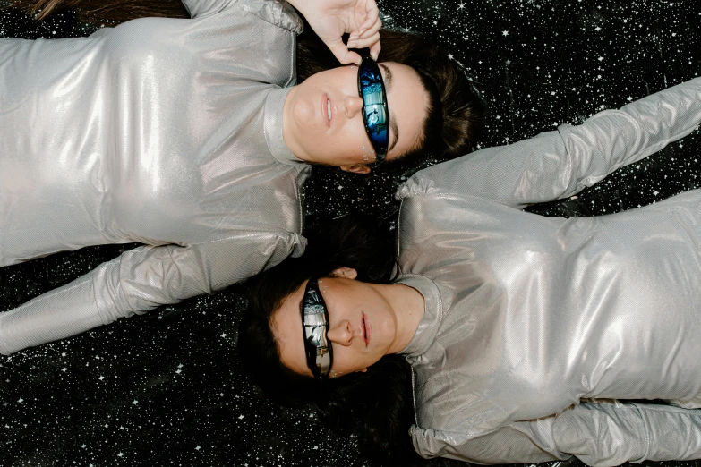 a couple of people laying on top of each other, an album cover, by Julia Pishtar, holography, wearing shiny black goggles, photo from space, beautiful sci - fi twins, grey shift