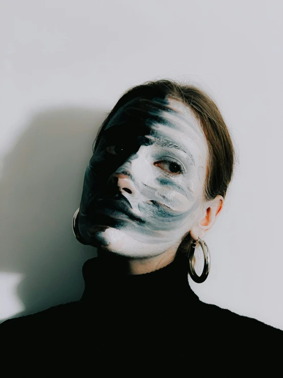 a woman with white paint on her face, a black and white photo, trending on pexels, pale grey skin, album cover, full body and face, stripe over eye