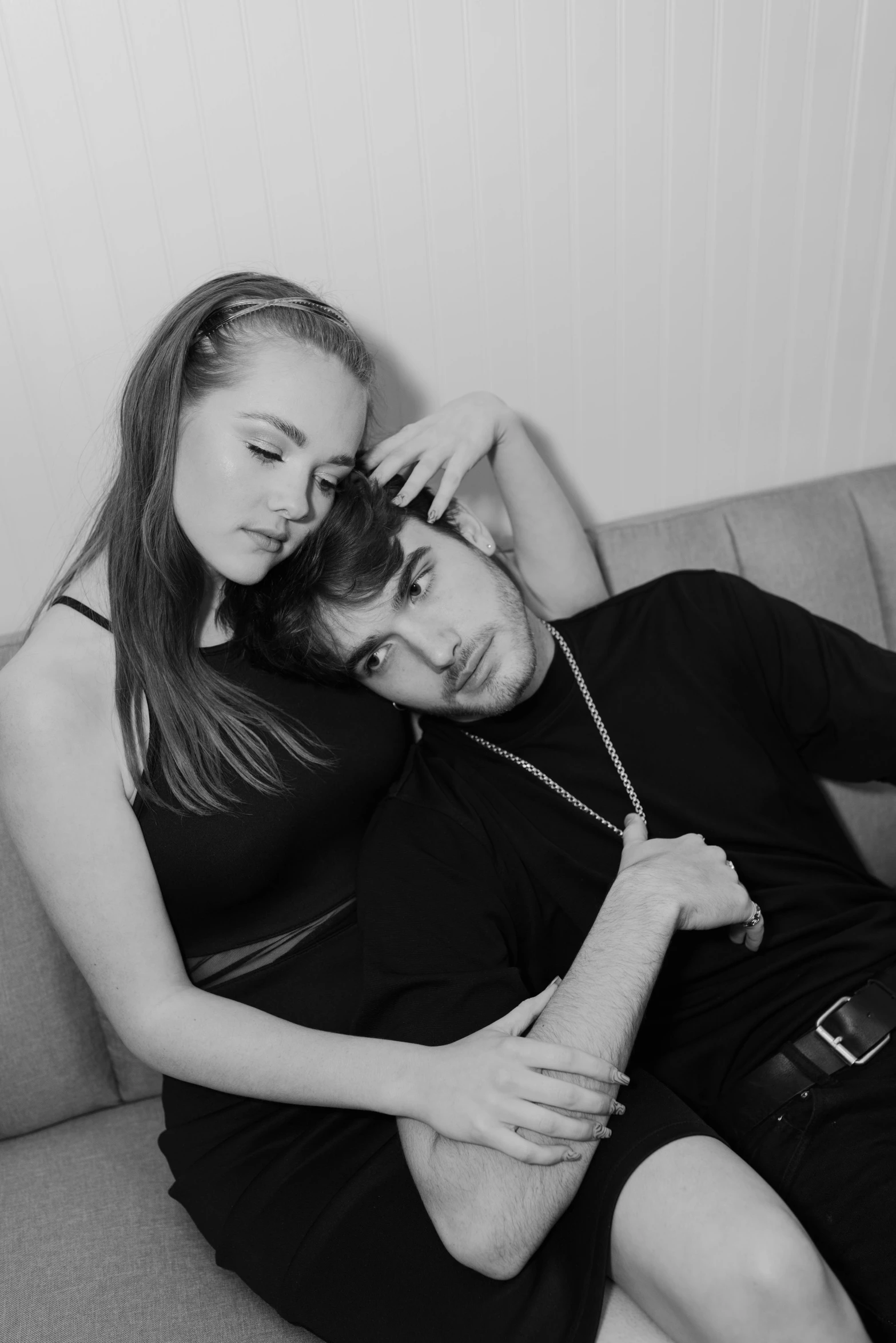 a man and a woman sitting on a couch, a black and white photo, tumblr, sophie turner, arm around her neck, liam brazier and nielly, concept photoset