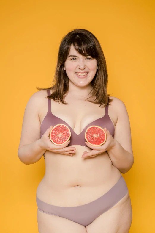 a woman in a bikini holding two grapefruits, shutterstock contest winner, andy milonakis, wearing bra, scientific photo, toiletpaper magazine