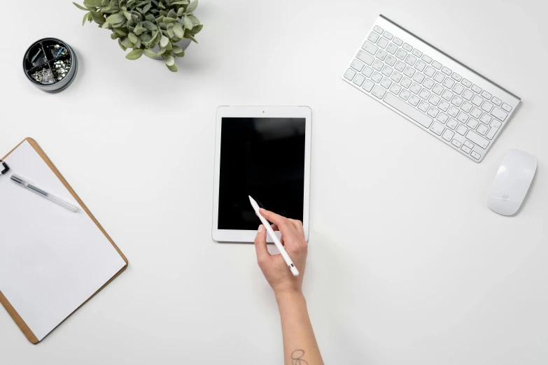 a person using a tablet computer on a desk, a picture, pexels, arbeitsrat für kunst, white minimalistic background, background image, top - down photograph, photoshoot