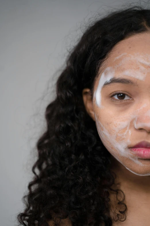 a woman with a lot of cream on her face, woman's face looking off camera, mixed-race woman, face and body clearly visible, face covered