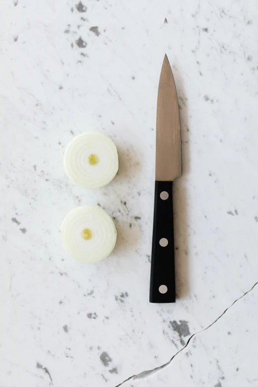 a knife and some onions on a table, inspired by Maki Haku, minimalism, black matte finish, chamomile, soft white rubber, detailed product image