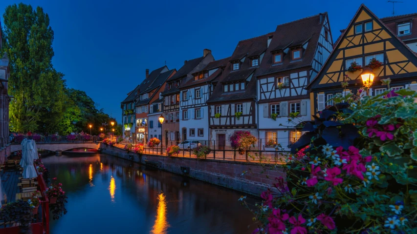 a river running through a town next to tall buildings, pexels contest winner, post-impressionism, evening lanterns, french village exterior, nuremberg, blue