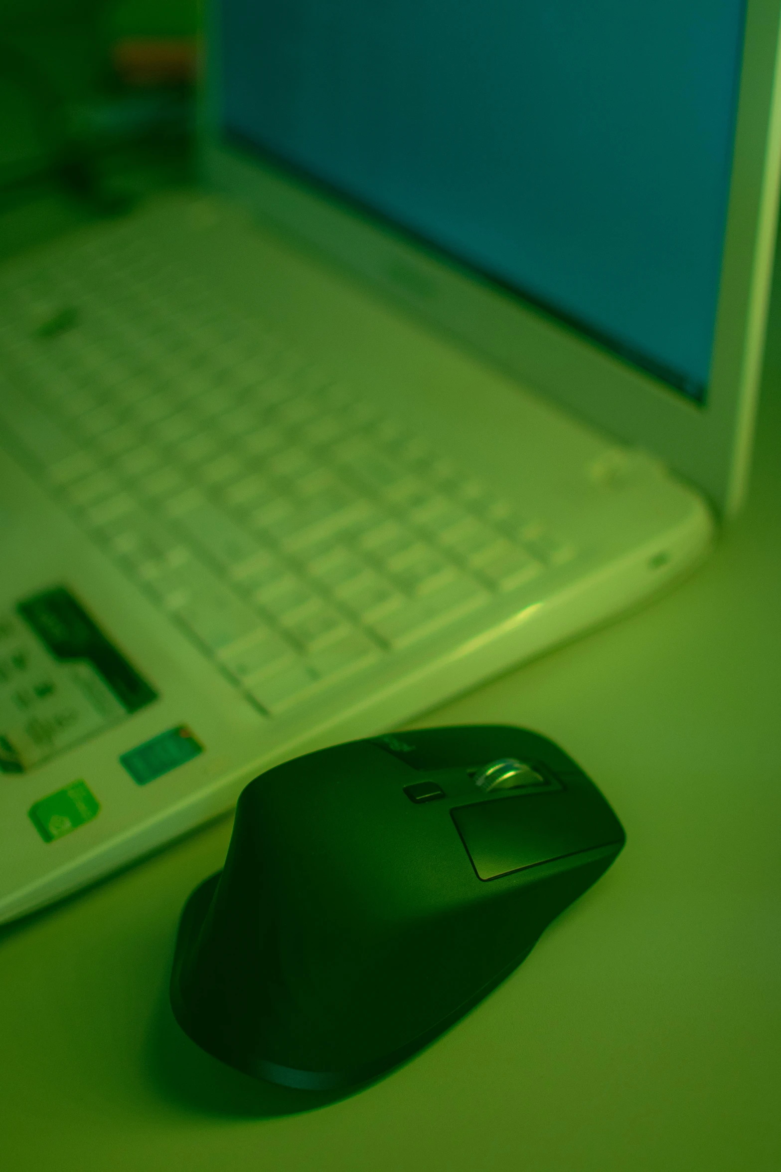 a computer mouse sitting next to a laptop computer, by Carey Morris, green ambient light, your personal data avatar, high angle shot, image