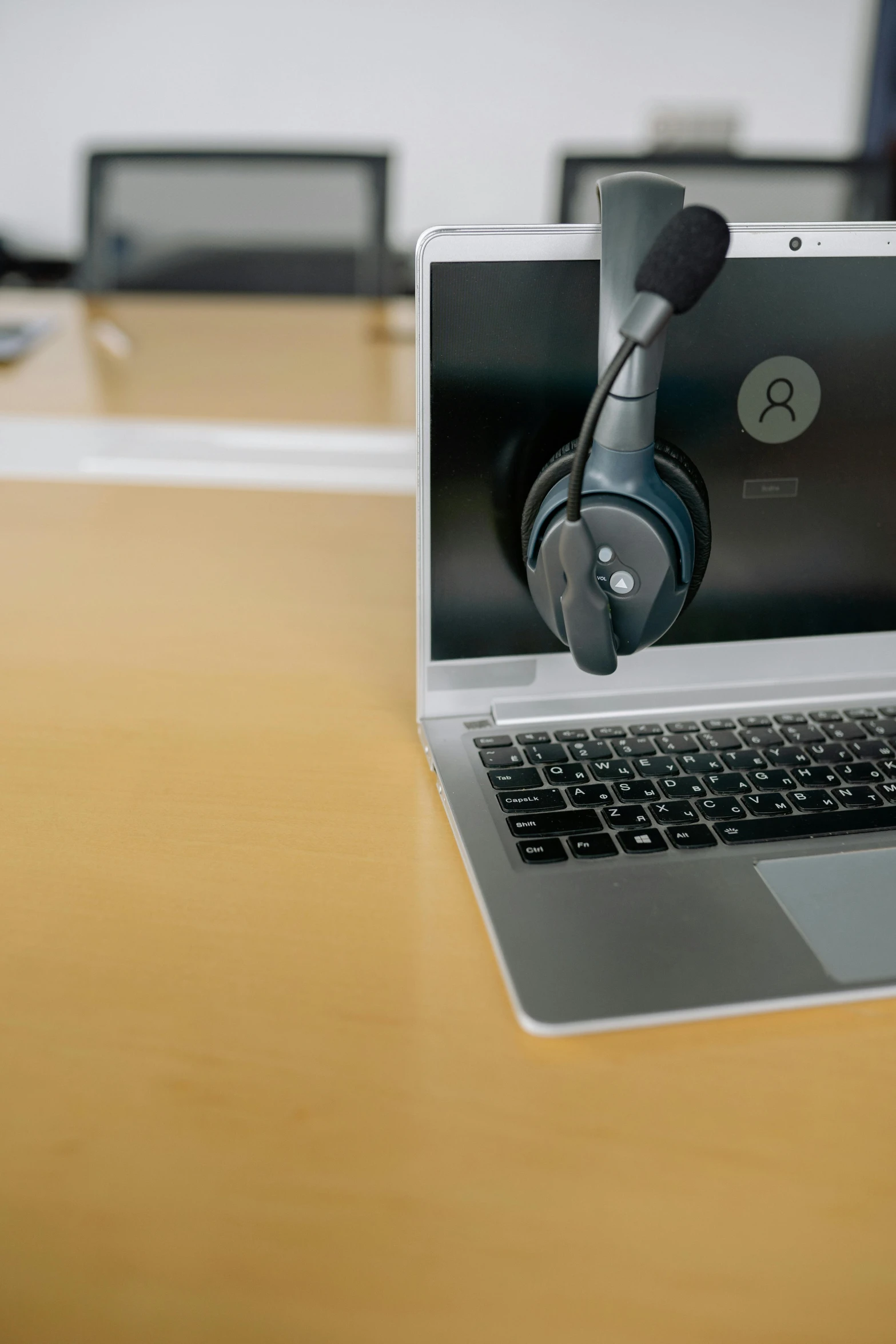 a laptop computer sitting on top of a wooden table, wearing a headset, sitting in front of a microphone, thumbnail, hires