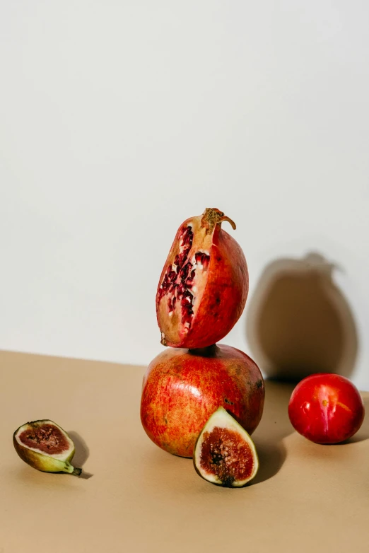 a bunch of fruit sitting on top of a table, a still life, trending on pexels, plain background, obsidian pomegranade, side profile shot, tall shot