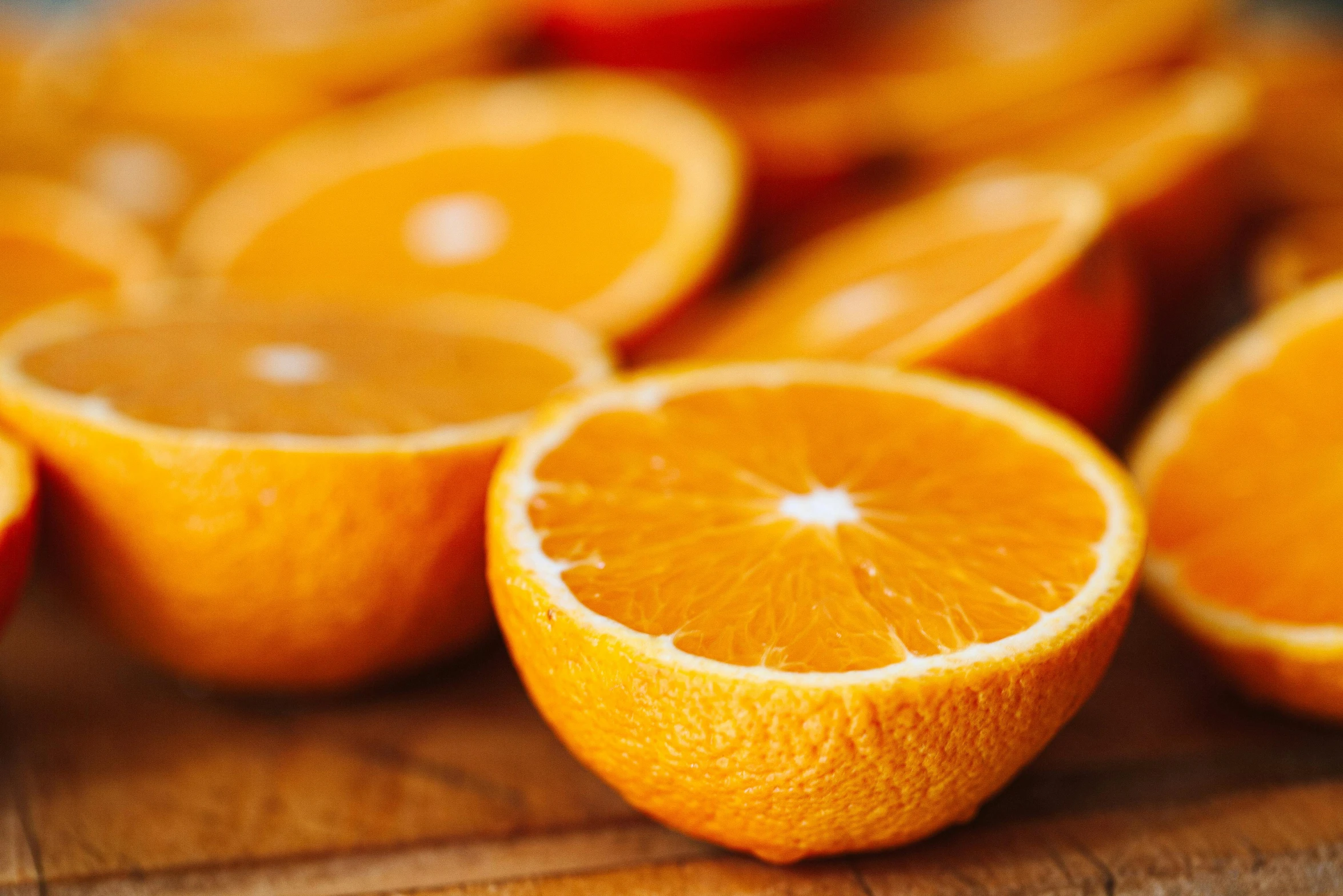 a bunch of oranges sitting on top of a wooden cutting board, by Jesper Knudsen, pexels, 🦩🪐🐞👩🏻🦳, slices of orange, zoomed in, vibrant and vivid