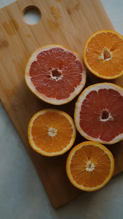 a cutting board with slices of grapefruit and oranges on it, an album cover, by Carey Morris, pexels, organic detail, neighborhood, blushing, juice