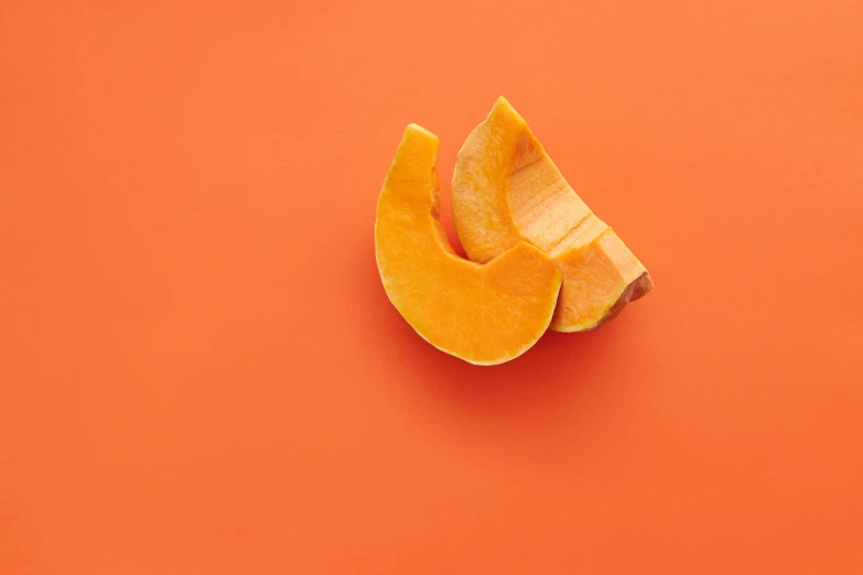 a cut up pumpkin on an orange background, unsplash, background image, dezeen, various posed, cut out