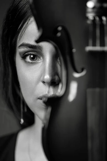 a woman holding a knife in front of her face, a black and white photo, inspired by irakli nadar, double bass, ana de armas, violin, hooked nose and square jaw