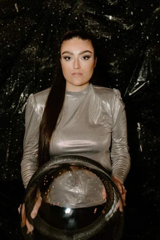 a woman holding a crystal ball in her hands, an album cover, inspired by Ion Andreescu, pexels contest winner, holography, sasha grey, wearing a space suit, ameera al-taweel, movie photo