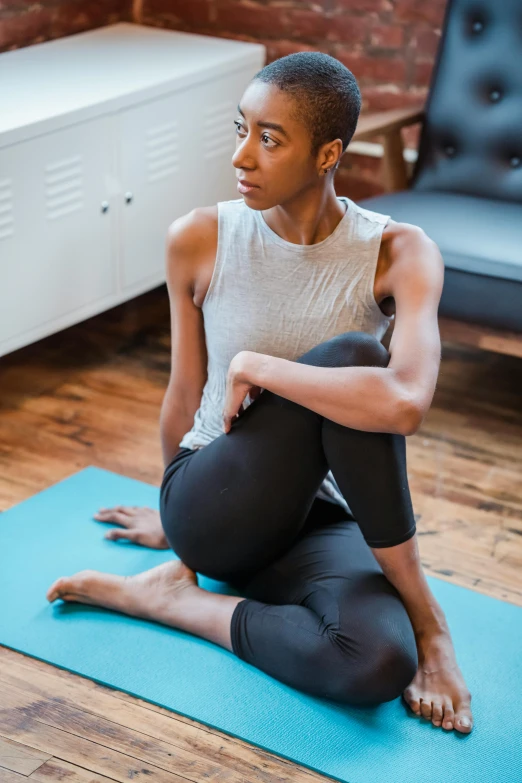 a woman sitting on a yoga mat in a living room, pexels contest winner, renaissance, african american young woman, low quality photo, thumbnail, multi-part