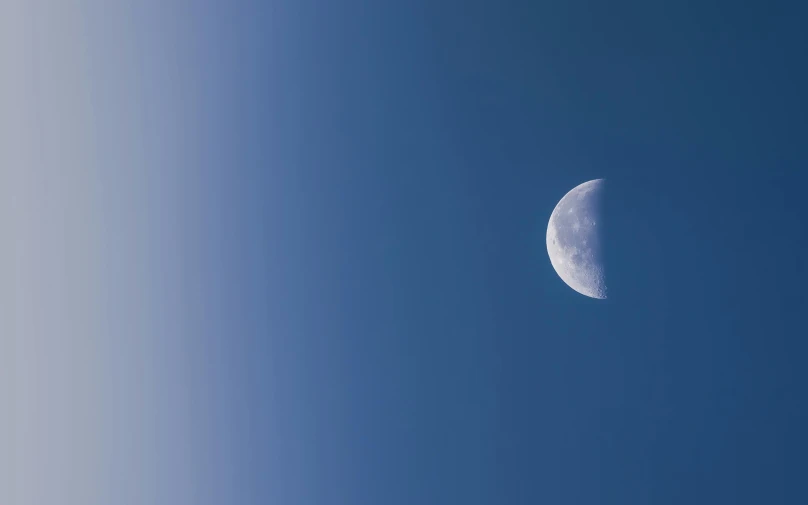 a half moon in a clear blue sky, inspired by John Moonan, unsplash, grey, high gradient, moons, wide