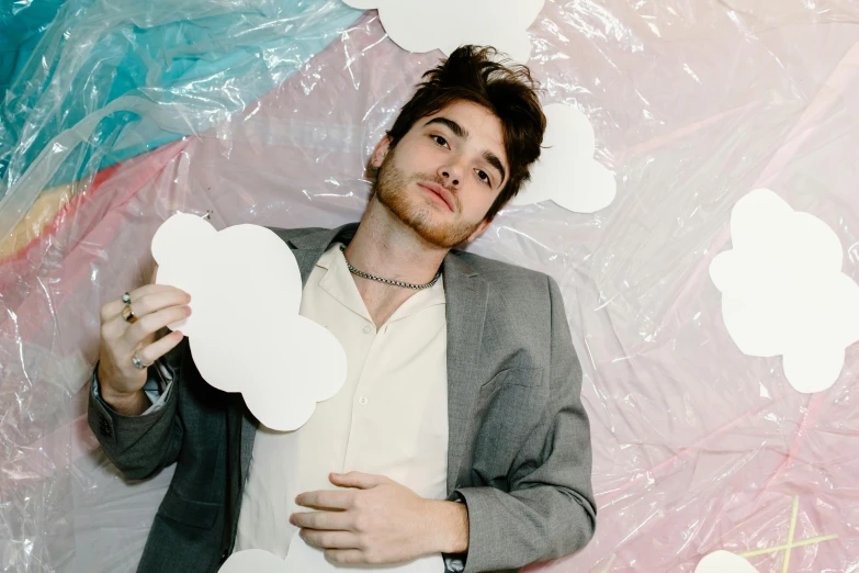 a man in a suit holding up paper clouds, an album cover, by Adam Dario Keel, official store photo, inflatable, all marble, blushing