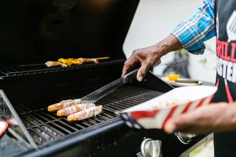 a man is cooking hot dogs on a grill, pexels contest winner, private press, stars and stripes, 15081959 21121991 01012000 4k, instagram post, serving rack of ribs