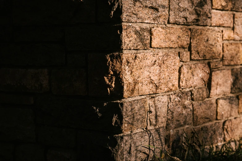 a fire hydrant sitting next to a brick wall, inspired by Elsa Bleda, unsplash, australian tonalism, background image, evening sunlight, zoomed in shots, stone brick