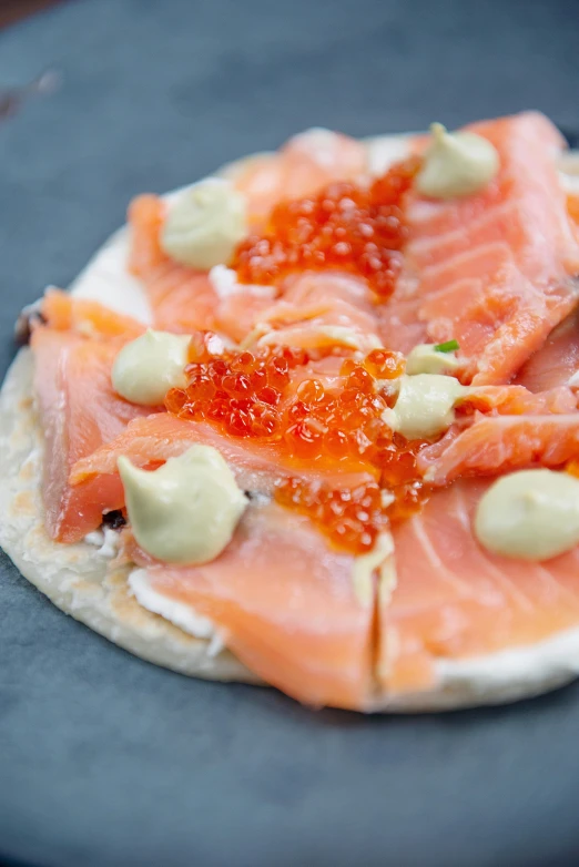 a close up of a plate of food on a table, salmon, brood spreading, folded, round-cropped