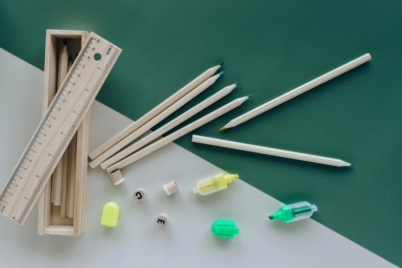 a group of pencils sitting on top of a table, by Eden Box, green neon details, various items, light wood, full product shot