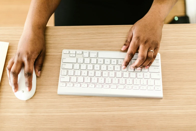 a close up of a person typing on a keyboard, by Carey Morris, trending on pexels, standing on a desk, brown, basic background, background image