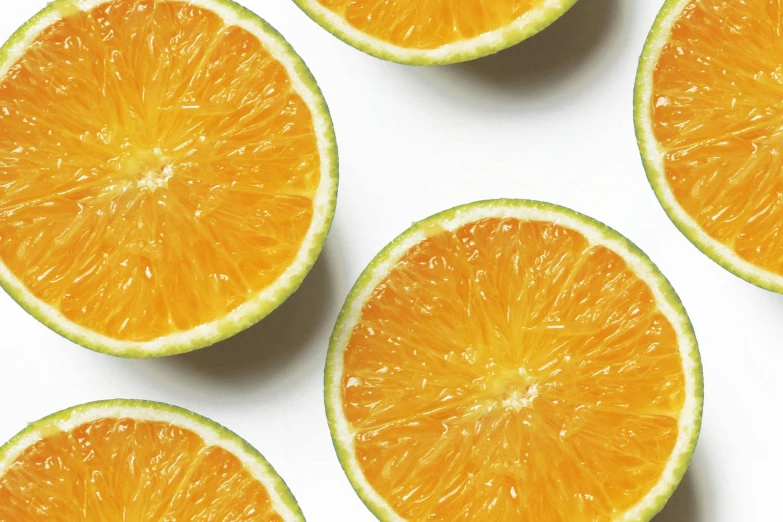 a group of oranges cut in half on a white surface, trending on pexels, background image, uncrop, graphic print, vibrant colour