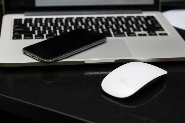 a laptop computer sitting on top of a desk next to a mouse, by Niko Henrichon, iphone background, square, iphone, dark-skinned