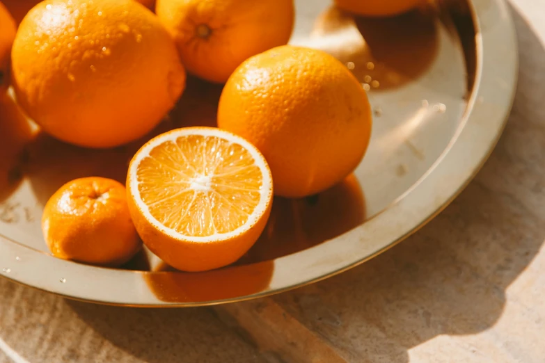 a plate of oranges sitting on a table, trending on pexels, bright dappled golden sunlight, thumbnail, high quality product image”, orange metal ears