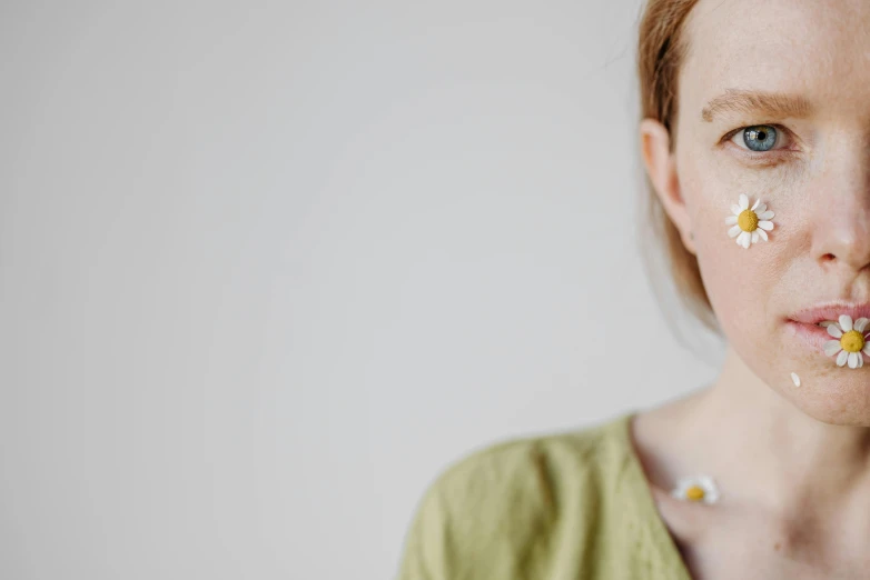 a close up of a woman with flowers on her face, a character portrait, by Emma Andijewska, trending on pexels, wearing a green sweater, ginger hair with freckles, full body image, blurry face