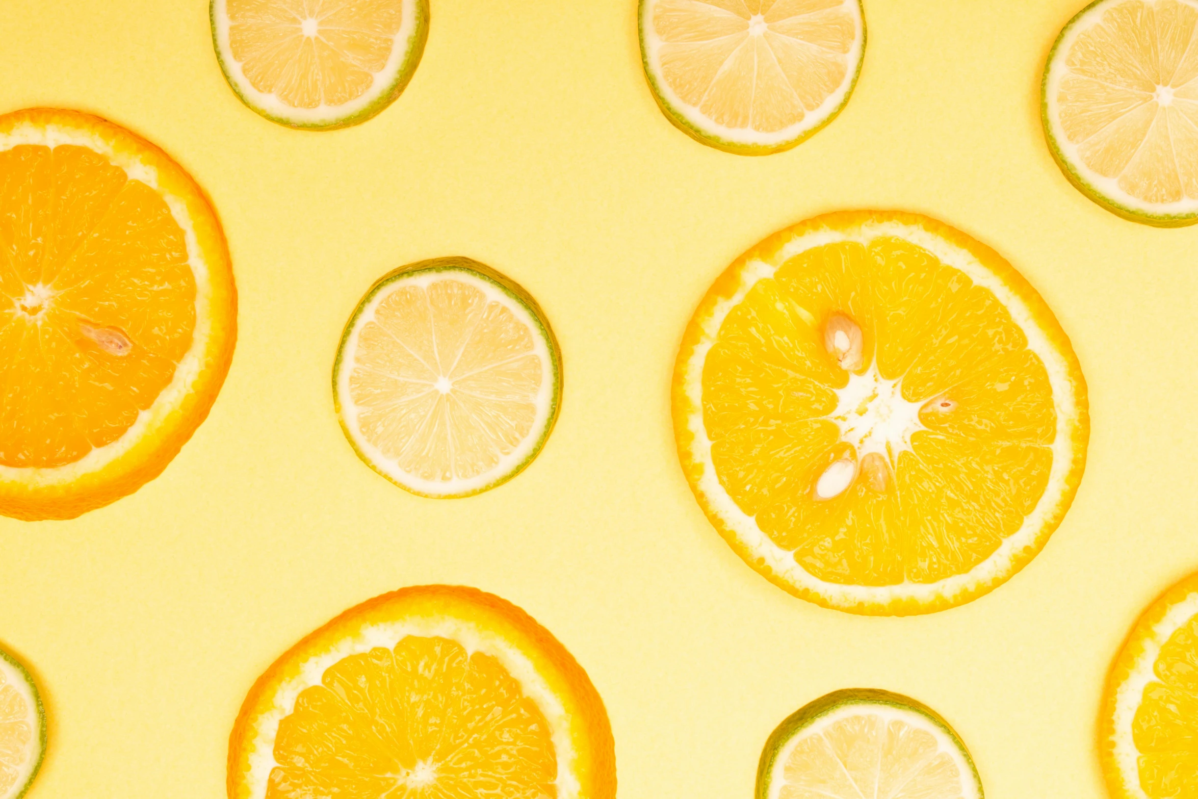 a group of oranges cut in half on a yellow background, by Carey Morris, trending on pexels, skincare, background image, lemonade, yellow and green scheme